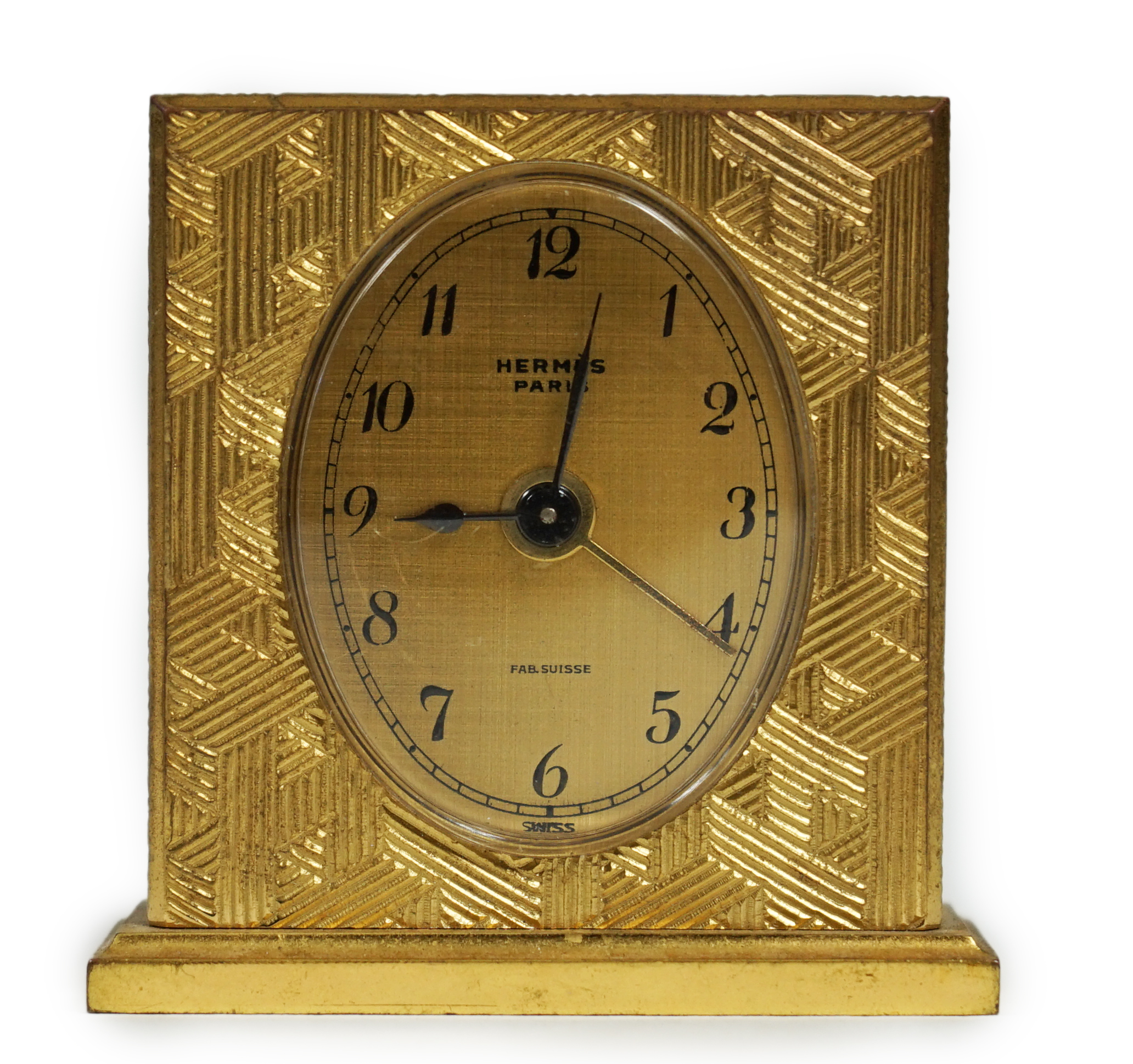 A Hermès travel alarm clock in gilded brass chiselled with H enchassés, height 5cm